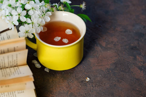 istock A Cup of green spring tea . Cherry blossoms and a book on the table with copy space 1148810294