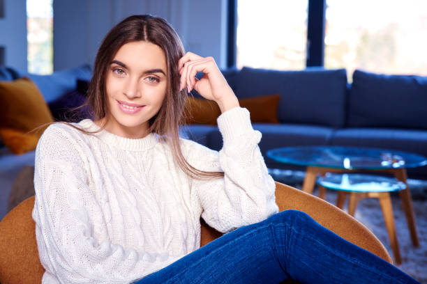 istock Cheerful young woman relaxing on sofa at home 1148810488
