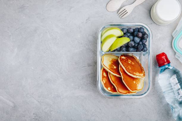istock Meal prep containers with pancakes, blueberry and apple. Breakfast in lunch box. Top view. 1148812156
