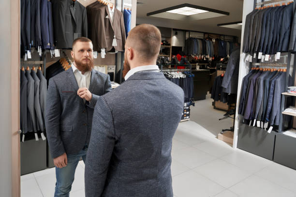 istock Serious man wearing and choosing new grey jacket 1148813434