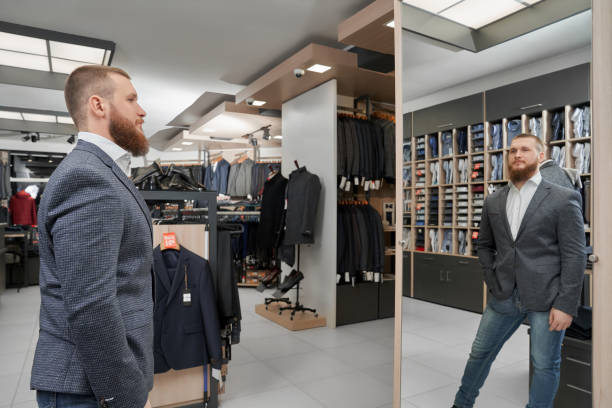 istock Man in jacket keeping hand in glove and looking at mirror 1148813439