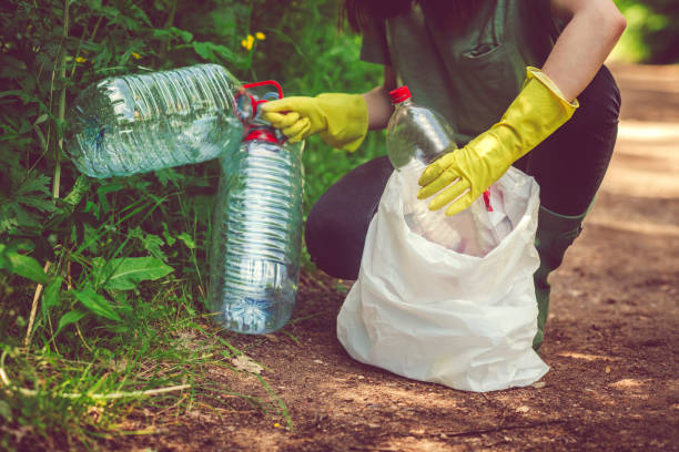 istock Volunteer collects garbage - plastic bottles in spring or summer outdoors 1148815478