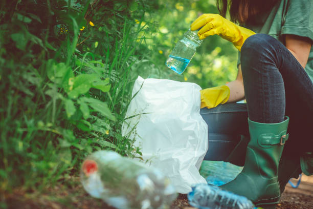 istock Volunteer collects garbage - plastic bottles in spring or summer outdoors 1148815492