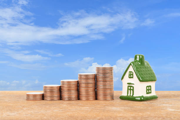 istock Model house and coin stack on blue sky background mortgage saving concept 1148815783