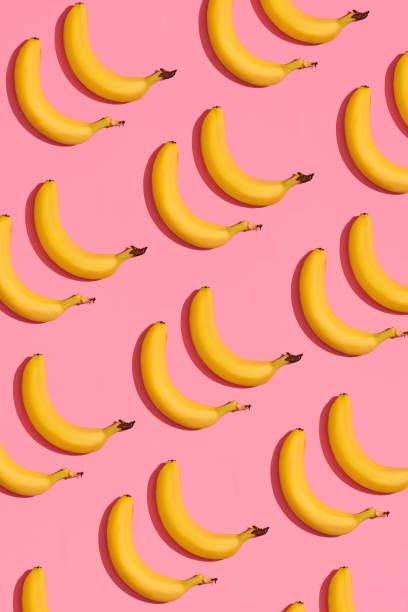 istock Pattern composition of a pair of bananas lying next to a pink background , top view 1148815939