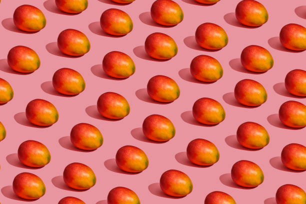 istock Pattern composition of a sweet tasty mango lying next to a pink background , top view 1148816008