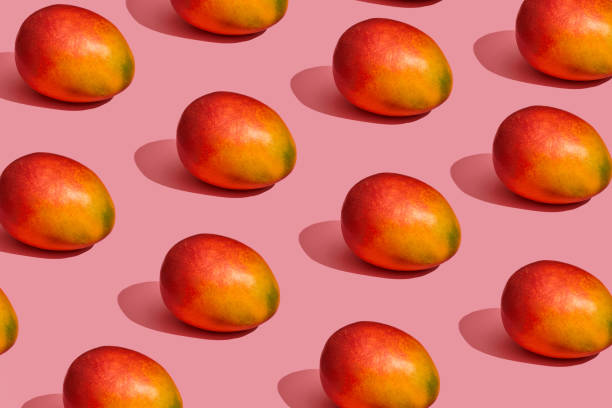 istock Pattern composition of a sweet tasty mango lying next to a pink background , top view 1148816013