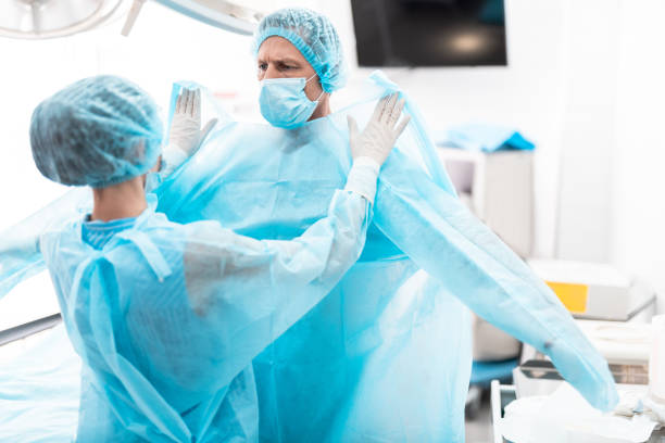 istock Assistant helping surgeon to prepare for surgical operation 1148818258
