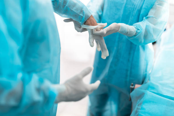 istock Nurse helping doctor to prepare for surgical operation 1148818265