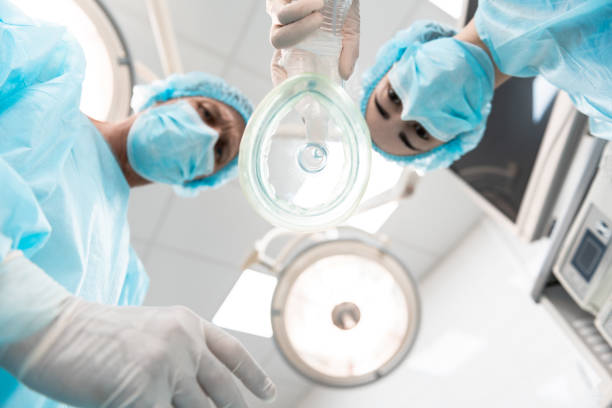 vista inferior de la mascarilla anestésica y dos doctores parados cerca de - anestesista fotografías e imágenes de stock