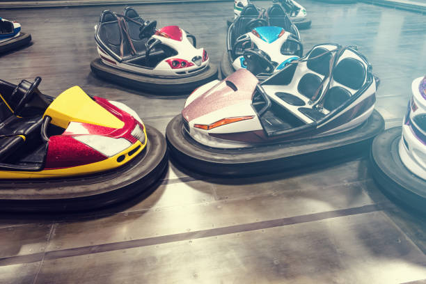 Happy couple having fun while driving bumper car at amusement park. Blurred motion. Copy space.
