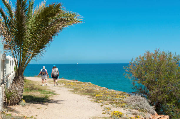 istock Tourist walk down a walkway along sea 1148820131
