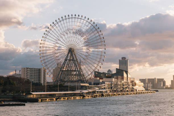 This photo was taken during sunset on the Santa Maria harbor sightseeing cruise ship while sailing around on Aji River, Osaka bay, you can see the Tempozan Ferris Wheel sit next to the river.