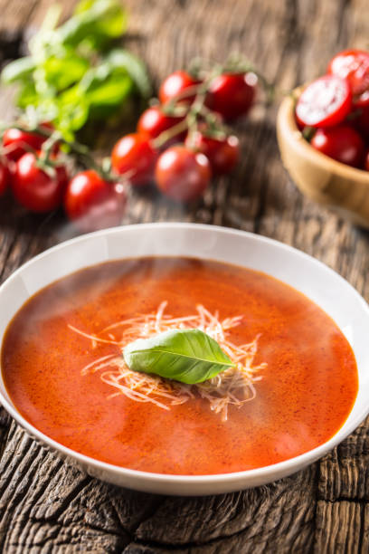 istock Hot tomato soup parmesan cheese and basil leave on old oal table 1148825000