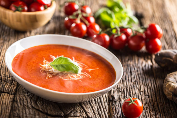 istock Hot tomato soup parmesan cheese and basil leave on old oal table 1148825004