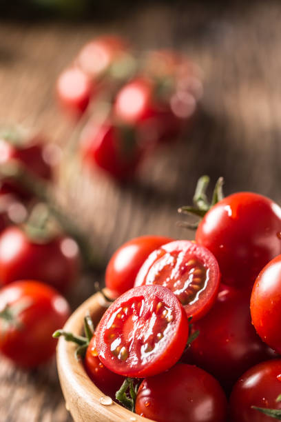 istock Fresh cherry tomatoes in wooden bowl on old oak table 1148825012