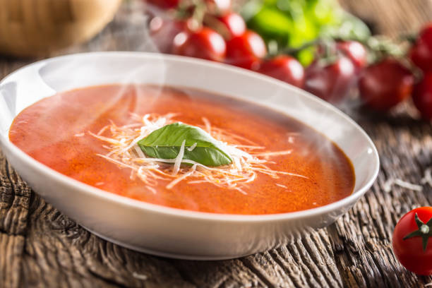 istock Hot tomato soup parmesan cheese and basil leave on old oal table 1148825013