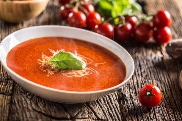 istock Hot tomato soup parmesan cheese and basil leave on old oal table 1148825015