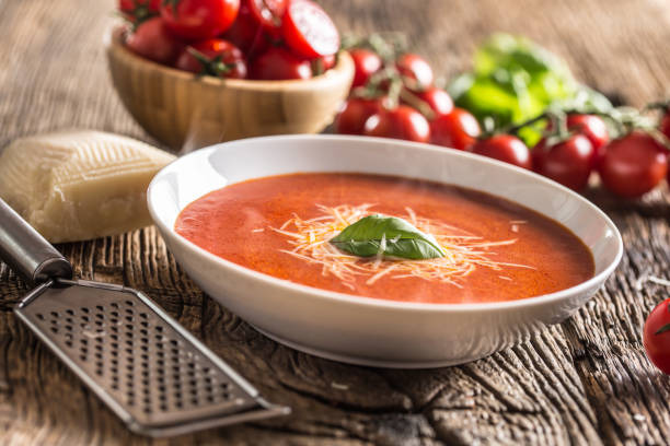 istock Hot tomato soup parmesan cheese and basil leave on old oal table 1148825053