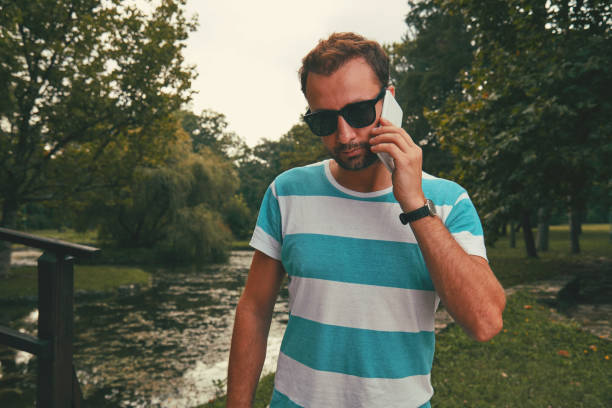 Trendy man using cellphone outdoors.