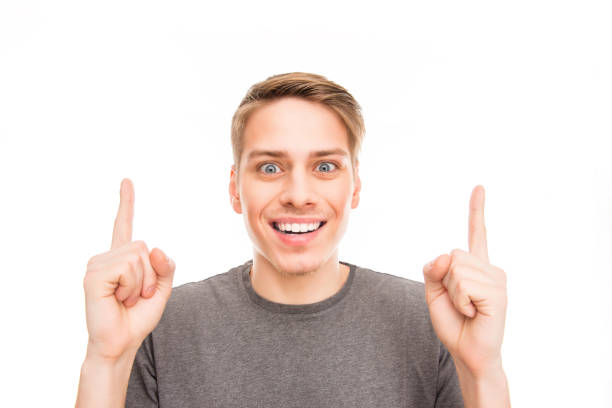 istock Smilling handsome man gesturing with fingers and pointing up 1148825673