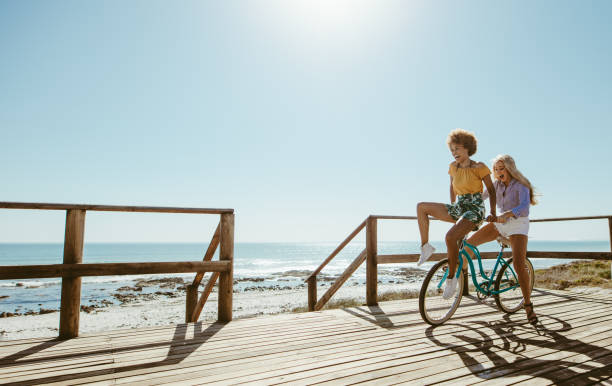 istock Joyful friends riding a bicycle 1148825880