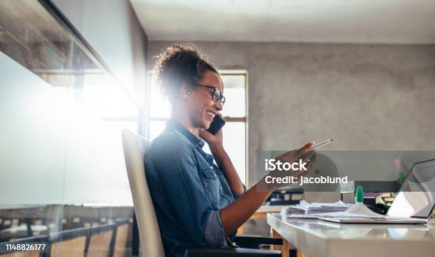 Businesswoman In Conversation Over Phone Stock Photo - Download Image Now - Owner, Business, Small Business