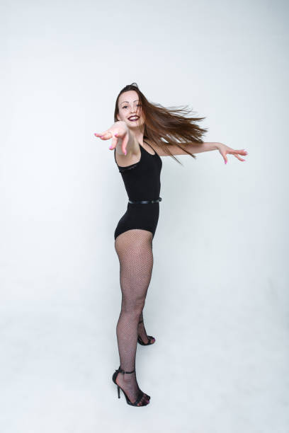 istock A young girl, a dancer stands with her hand outstretched on a light background. Wave your hands. 1148827554