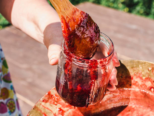 istock Old, copper pan, wooden spoon and plum jam 1148829299