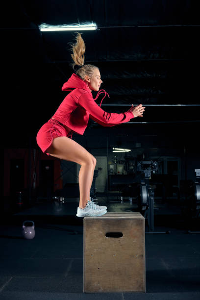 istock Female athlete is performing box jumps at gym. 1148830640