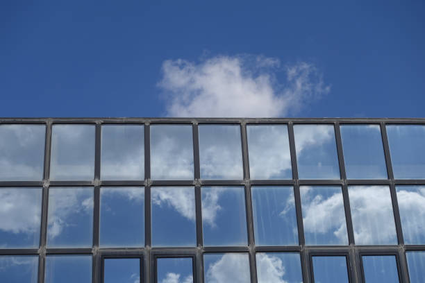 istock Reflections of clouds and blue sky on building windows 1148832376
