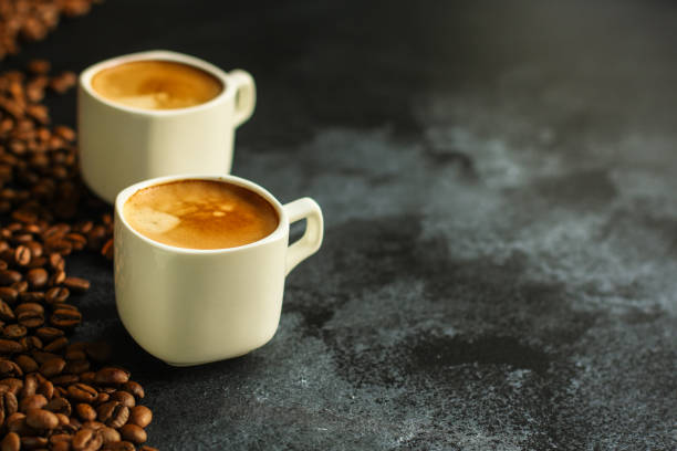 istock coffee in a white cup and coffee grain scattered on the table (freshly brewed hot drink with foam). food background. top 1148834132