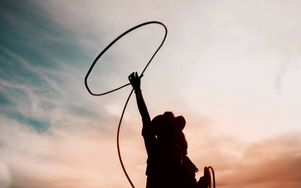 pretty Chinese cowgirl throwing the lasso pretty Chinese cowgirl throwing the lasso in a horse paddock on a wild west farm cowgirl stock pictures, royalty-free photos & images