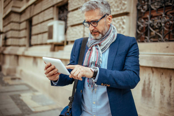 istock Fashionable Senior Man using reading glasses on digital tablet 1148840503