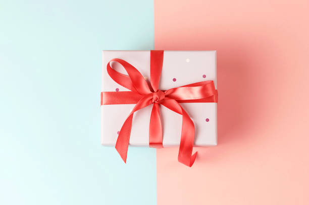 istock Gift box on pink and blue background close-up, top view 1148840637