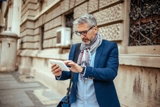 istock Fashionable Senior Man using reading glasses on digital tablet 1148843179