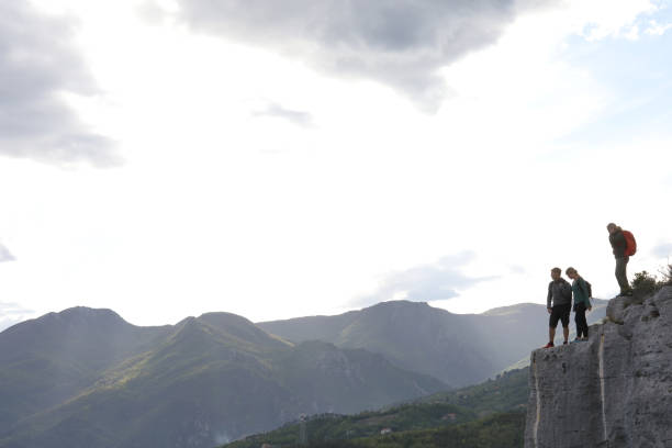 istock Group of hikers climb to mountain summit at sunrise 1148843221