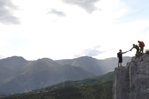 istock Group of hikers climb to mountain summit at sunrise 1148843770