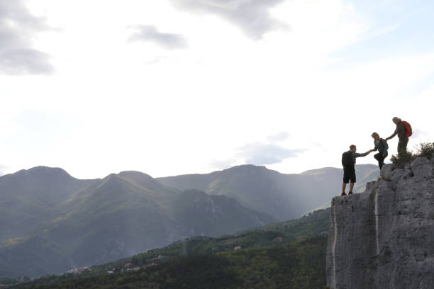istock Group of hikers climb to mountain summit at sunrise 1148843806