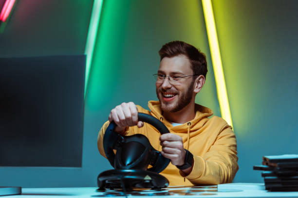 istock smiling and handsome man in glasses playing video game with steering wheel 1148844062