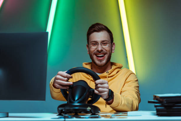 istock smiling, good-looking and handsome man in glasses playing video game with steering wheel 1148844068