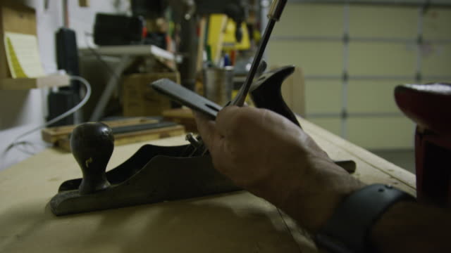 A Caucasian Man Takes Apart a #5 Plane and Resets the Blade and Frog in a Garage