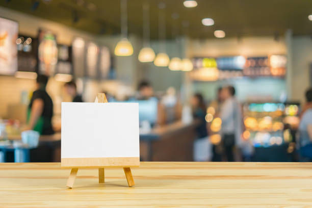 caballete con lienzo en blanco sobre mesa de madera, cartel en la parte superior de escritorio de madera con fondo bokeh suministrado, plantilla mock up para el montaje de la pantalla de su producto. vintage color - restaurant sign sign language food fotografías e imágenes de stock