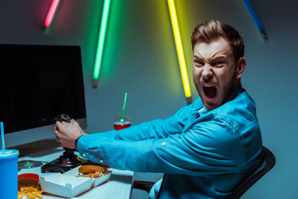 istock handsome and angry man holding joystick and looking at camera 1148844284