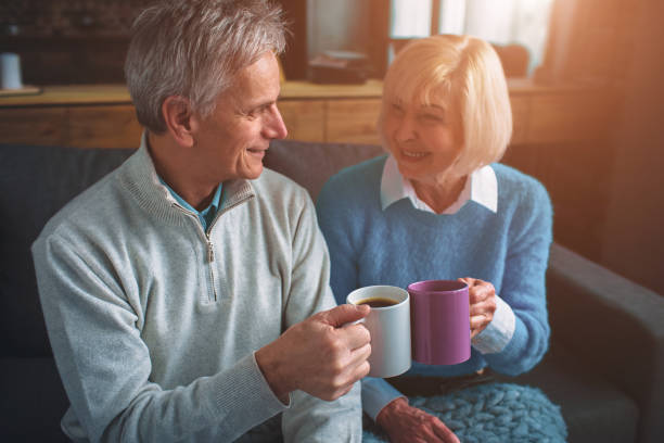 istock Husband and wife are sitting together and drinking tea from cups 1148844431