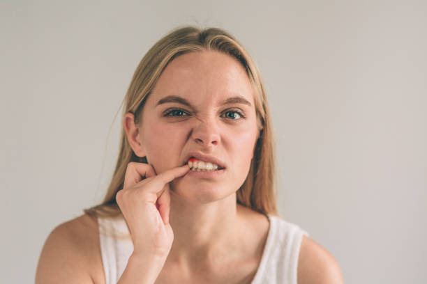 強い歯痛に苦しみ、彼女の頬に触れるチェッカーシャツの若い女性の水平写真 - healthy gums 写真 ストックフォトと画像