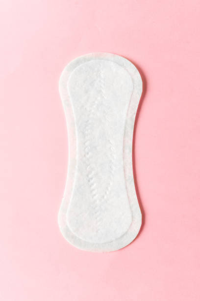 Feminine hygiene pad on a pink background. Concept of feminine hygiene during menstruation. top view. stock photo