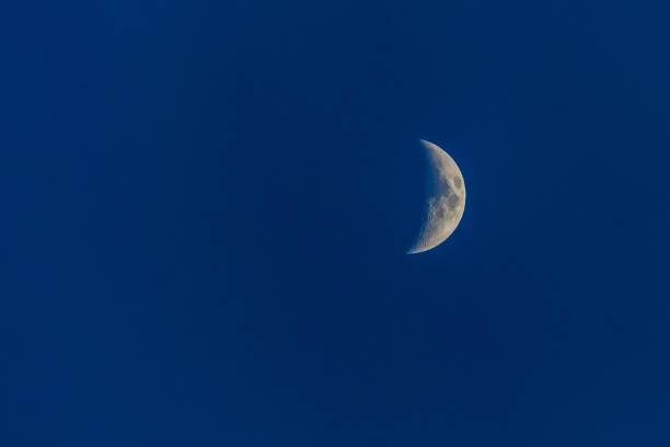 istock White half-moon on dark blue sky at night. 1148855174