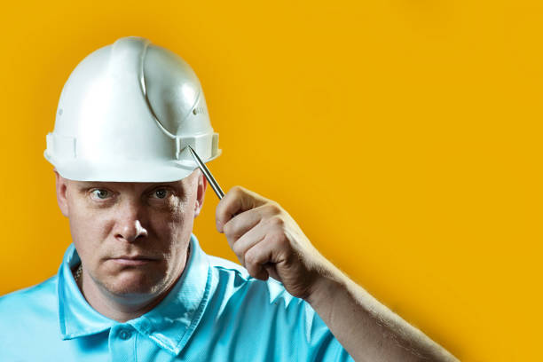 istock brutal man Builder in a white helmet on a yellow background 1148855328