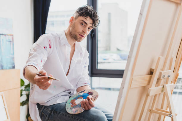 istock good-looking artist with palette and paintbrush looking at camera 1148855970